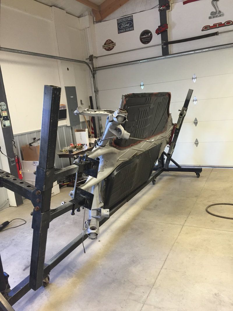 A large piece of metal is sitting in a garage next to a garage door.