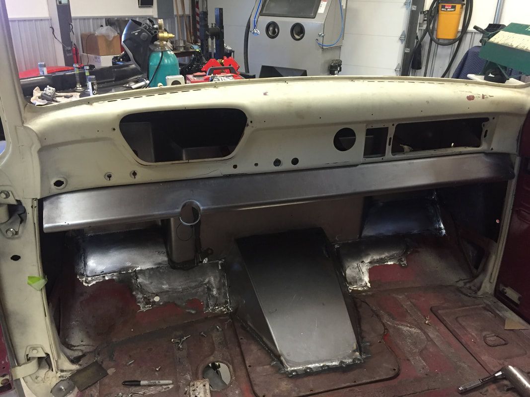 The dashboard of a car is being built in a garage.