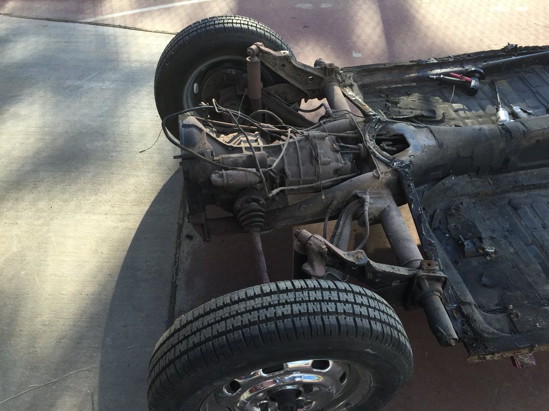 A car 's chassis is laying on its side on the ground