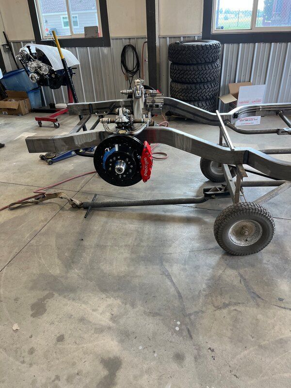 A car is being built in a garage with a trailer attached to it.