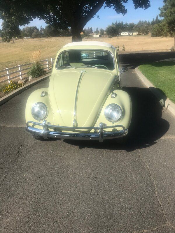 A yellow beetle is parked on the side of the road