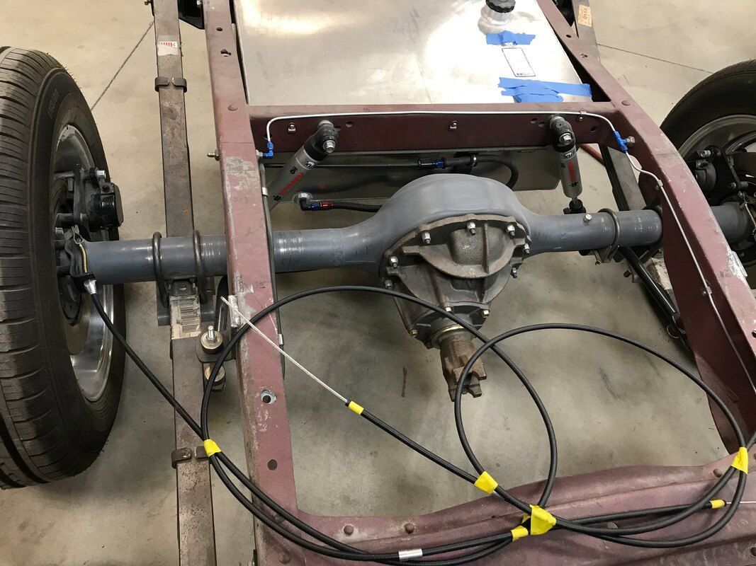 A car chassis with a rear axle and a fuel tank.