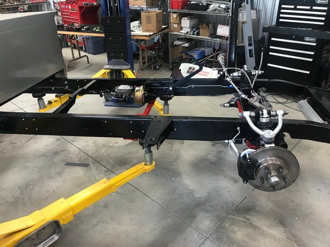 A car is being built in a garage with a yellow trailer attached to it.