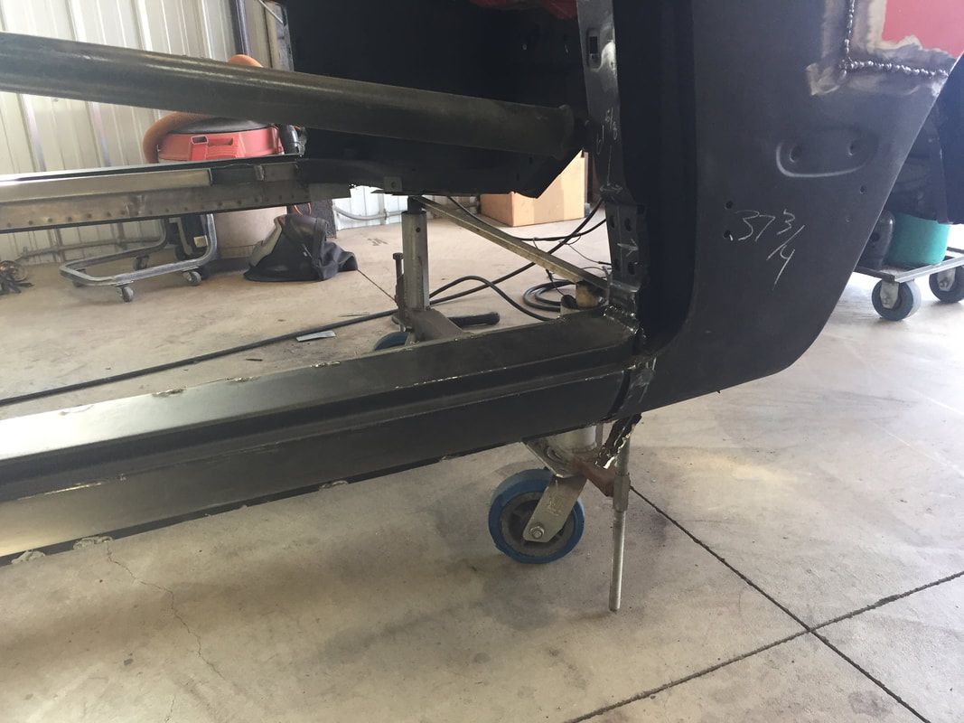 A black car is sitting on a concrete floor in a garage.