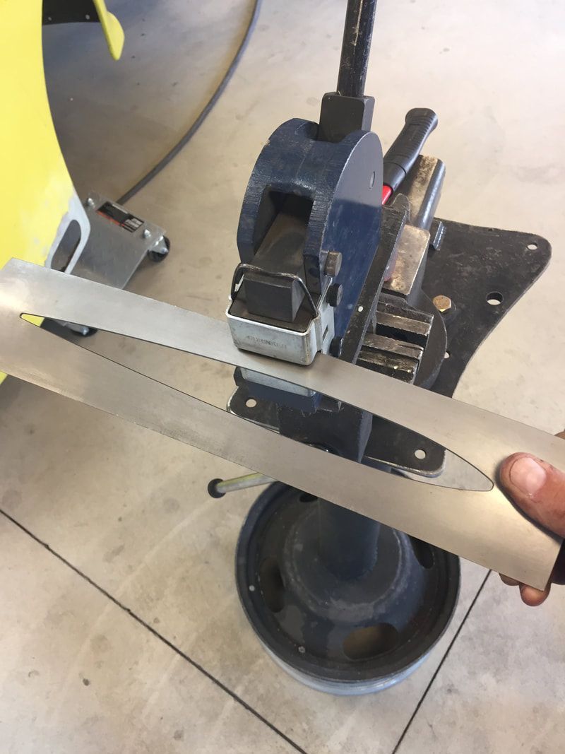 A person is cutting a piece of metal with a saw.