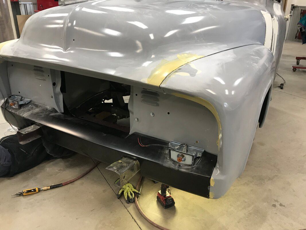 A car is being painted in a garage.