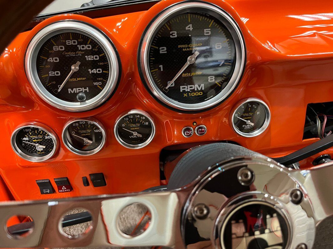 A close up of a car dashboard with a clock that says rpm on it