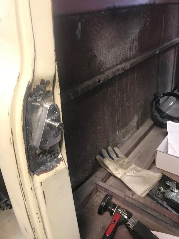 A pair of gloves is sitting on a wooden table next to a hammer.