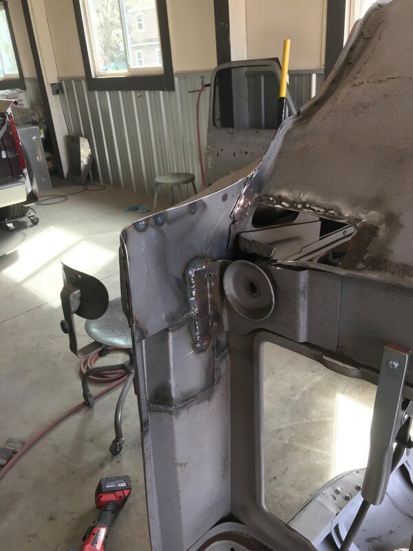 A piece of metal is being worked on in a garage.