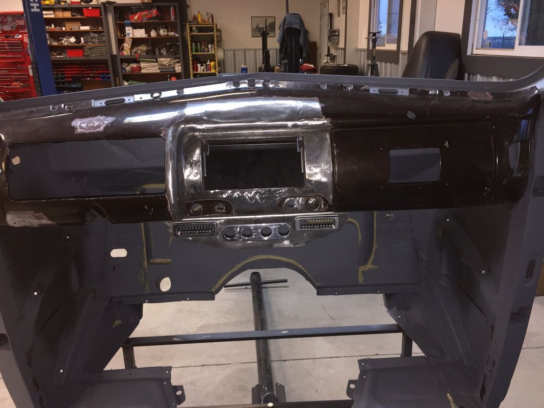 A car dashboard is sitting on a stand in a garage