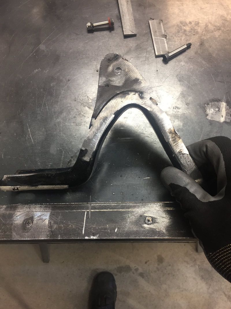 A person is holding a piece of metal on a table.