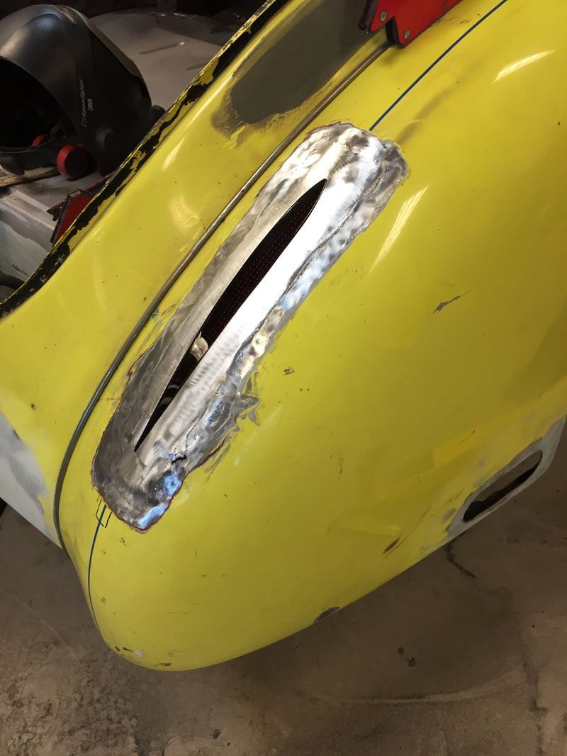 A close up of a yellow car with a hole in it