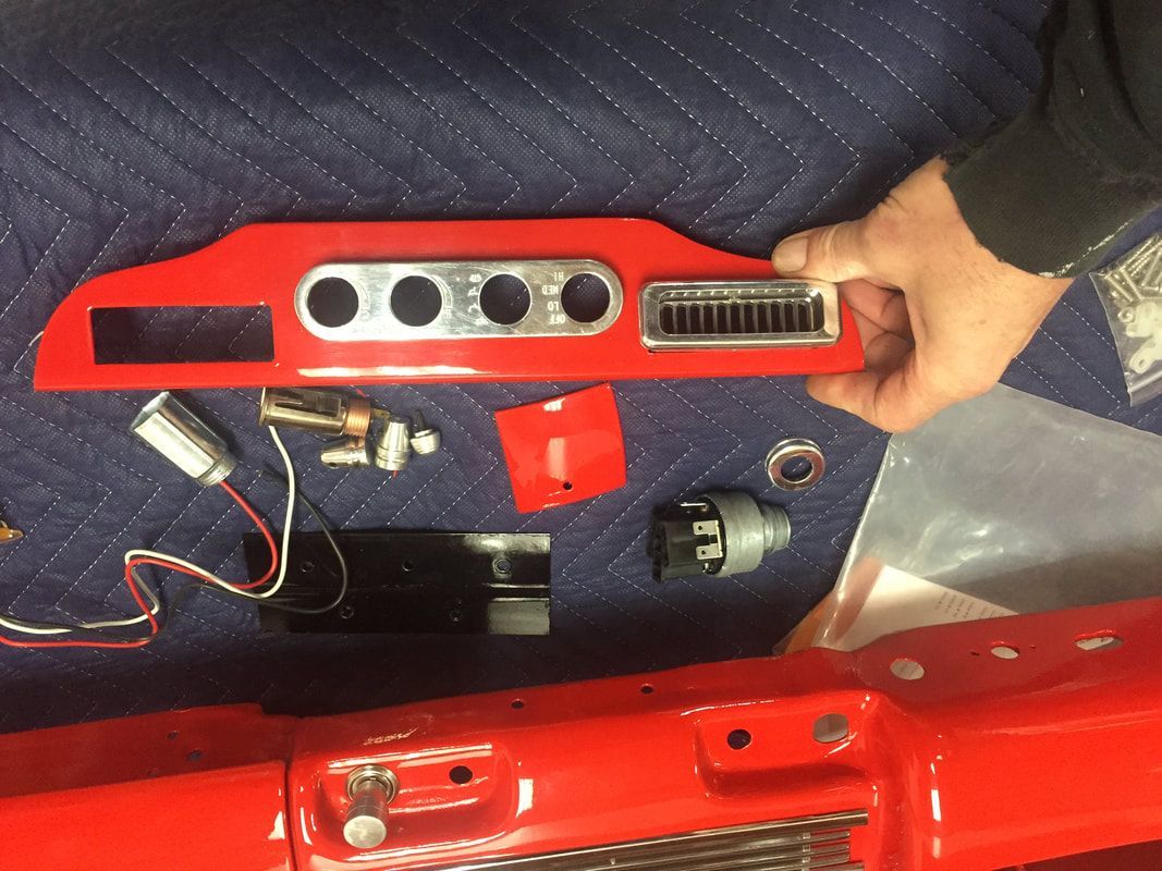 A person is holding a red piece of metal on a blue blanket.