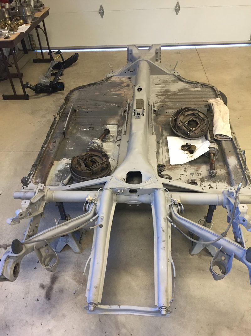 A car frame is sitting on a table in a garage.