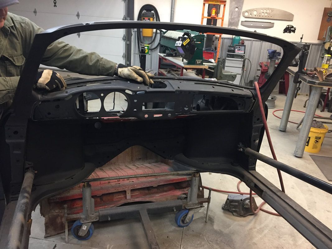 A man is working on a car in a garage