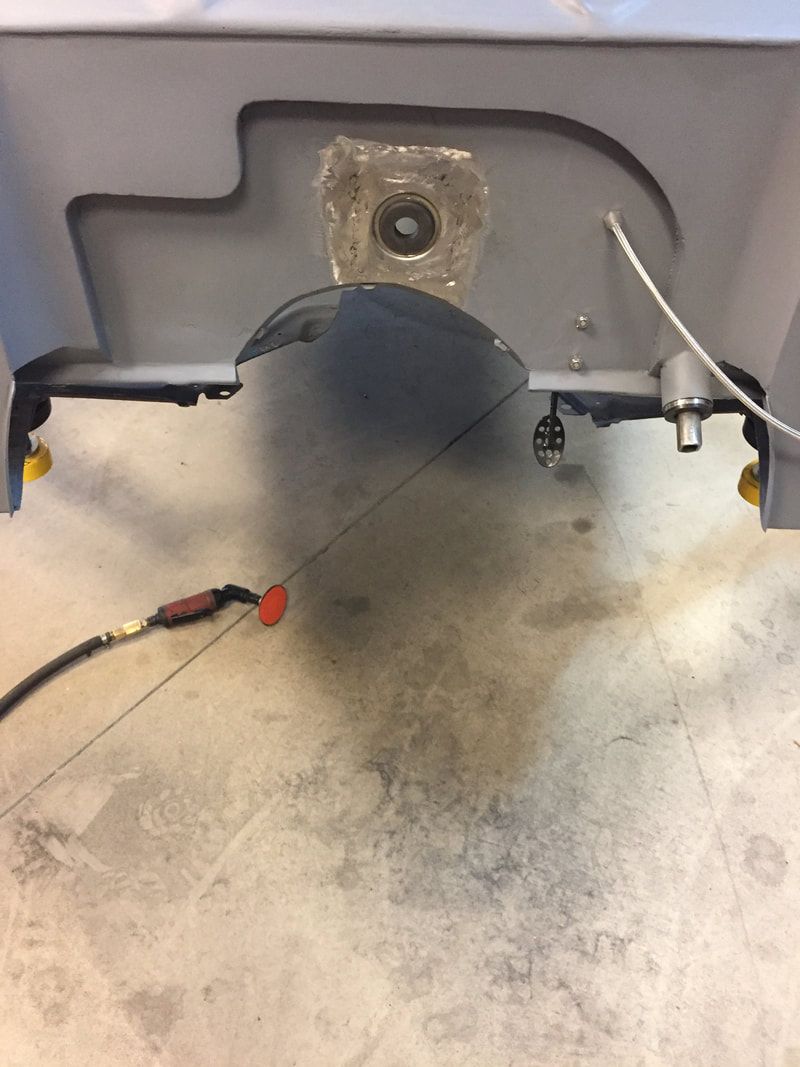 A machine is sitting on a concrete floor with a hose attached to it.