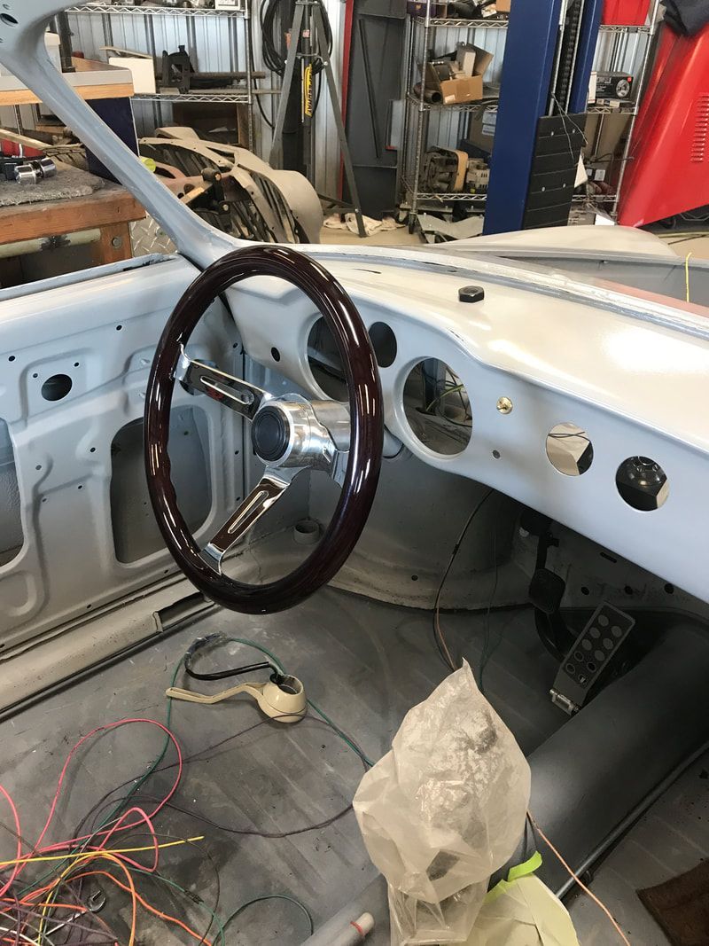 A car is being built with a wooden steering wheel