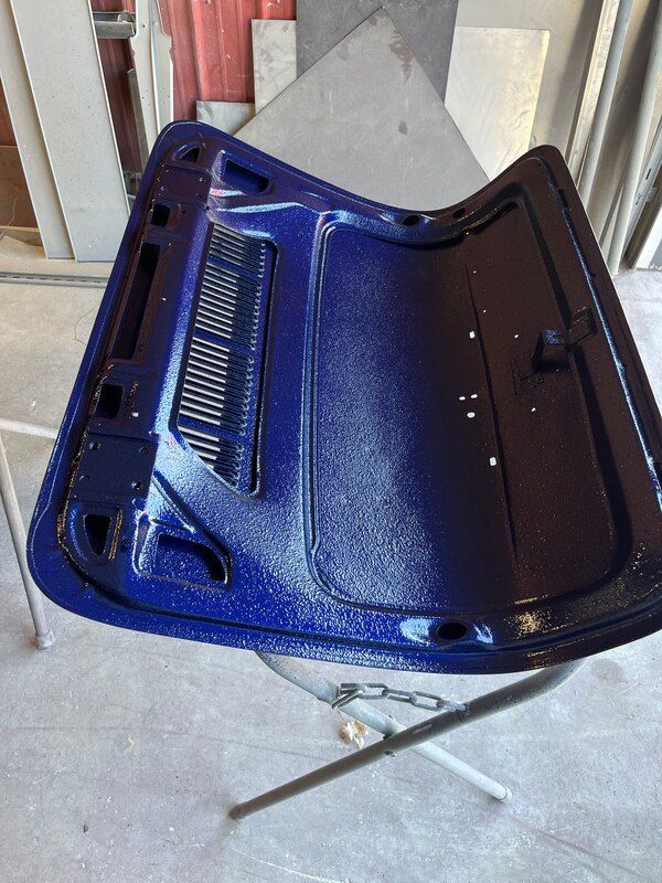 A blue hood is sitting on top of a metal stand.