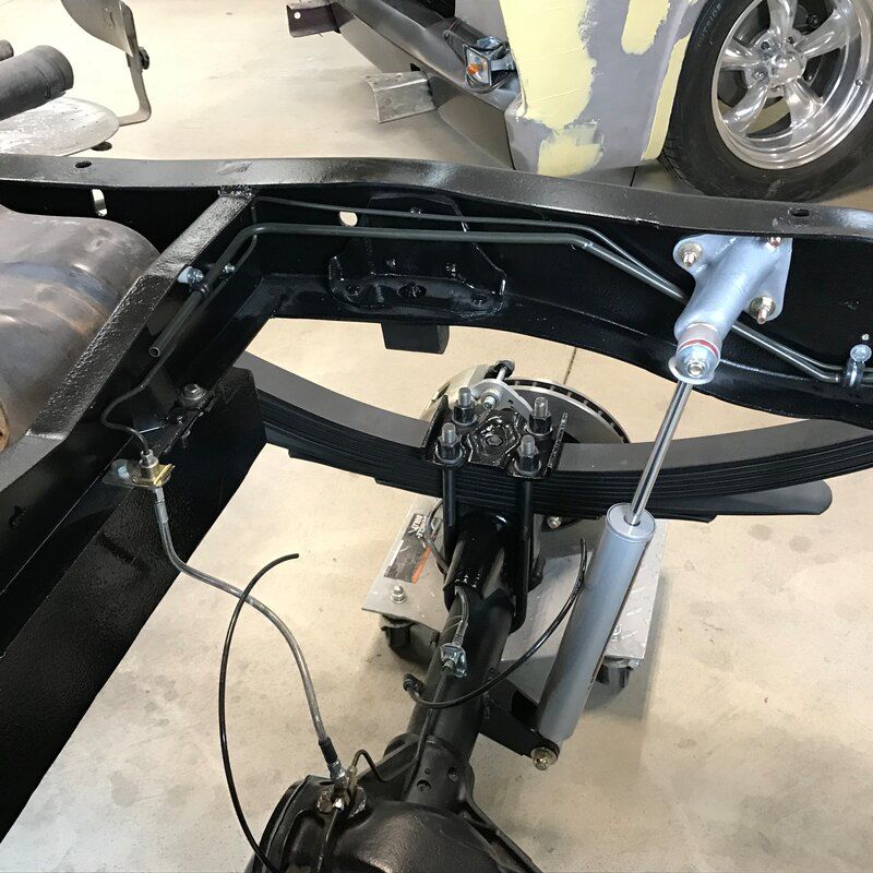 A car frame is sitting on the ground in a garage