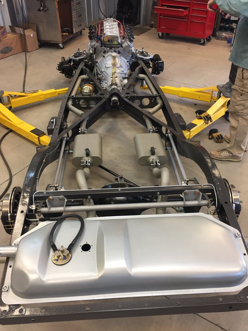 A car is being built in a garage with a fuel tank.