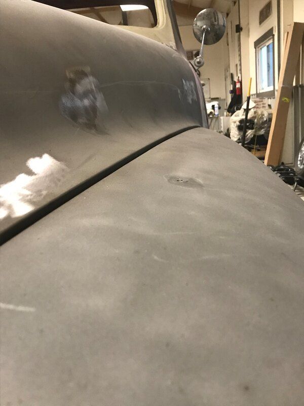 A close up of the hood of a car in a garage