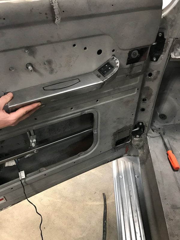 A person is holding the door handle of a car.