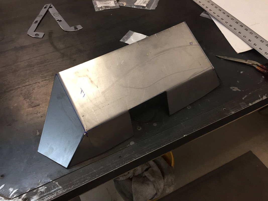 A piece of metal is sitting on a table next to a ruler