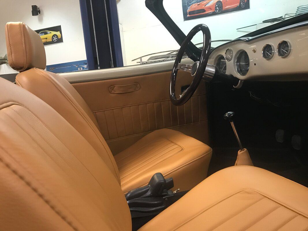 The interior of a car with brown leather seats and a steering wheel.
