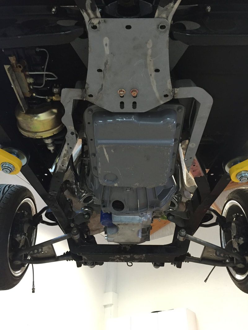 The underside of a car with the engine visible