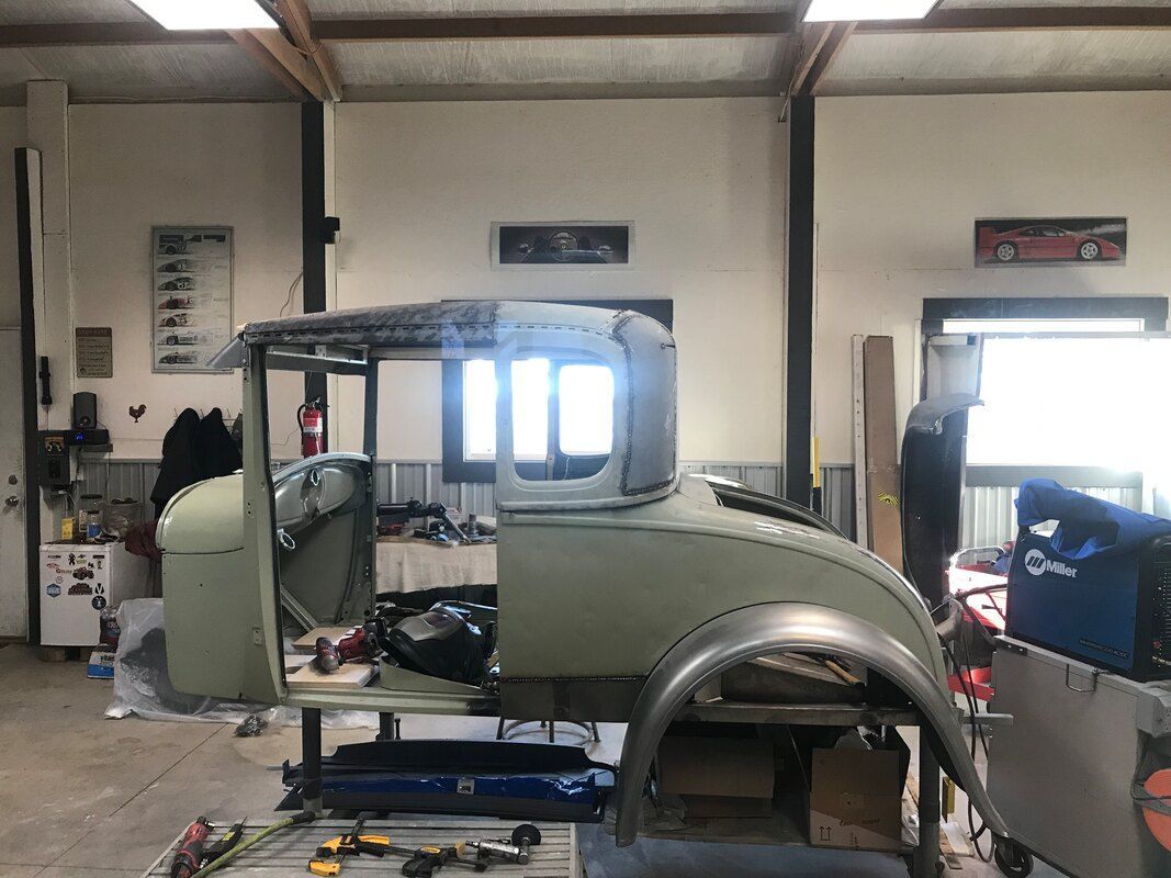 An old car is being built in a garage
