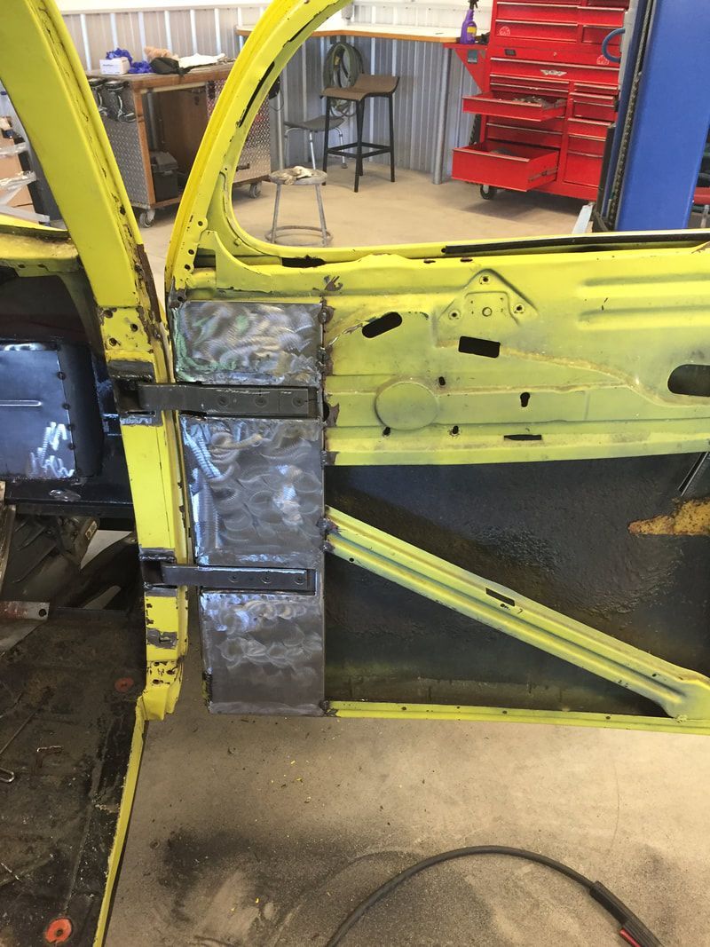 A yellow car is being worked on in a garage.