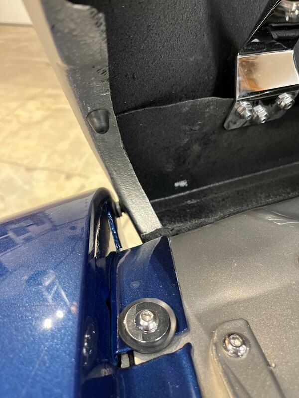 A close up of a blue motorcycle with the trunk open.