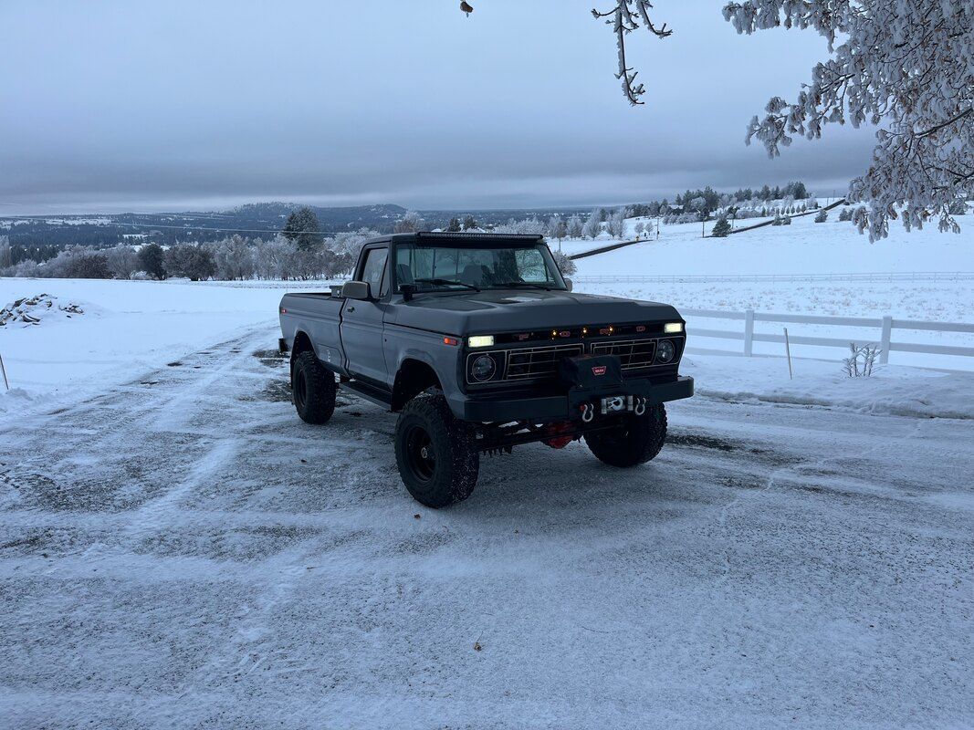 A truck is parked in the snow on a snowy road.