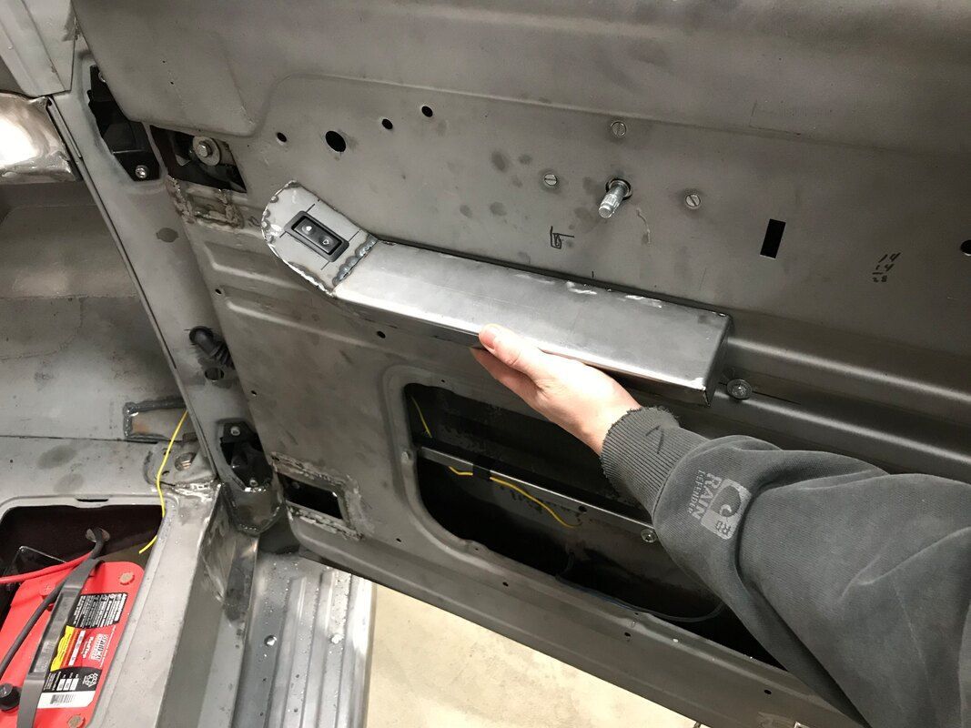 A person is holding a piece of metal in their hand in a car.