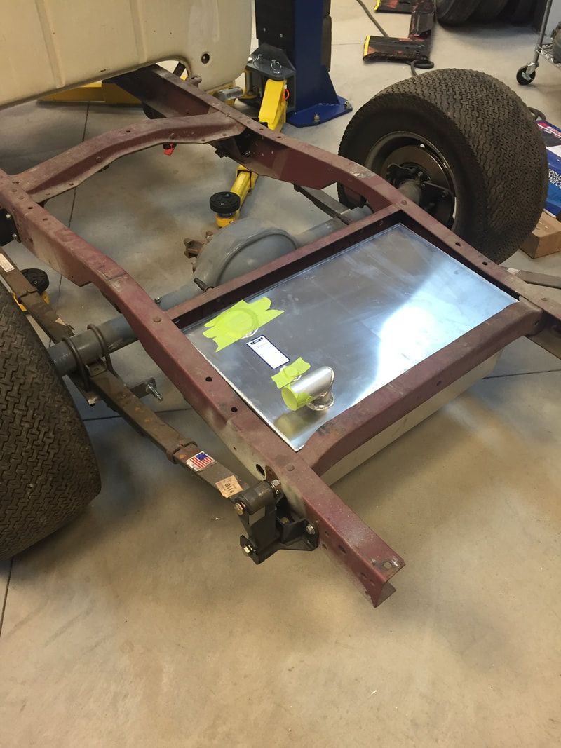 A metal frame is sitting on the ground next to a tire.