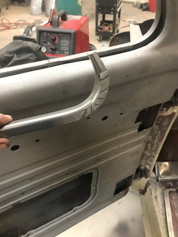 A person is holding a metal handle on a car door.