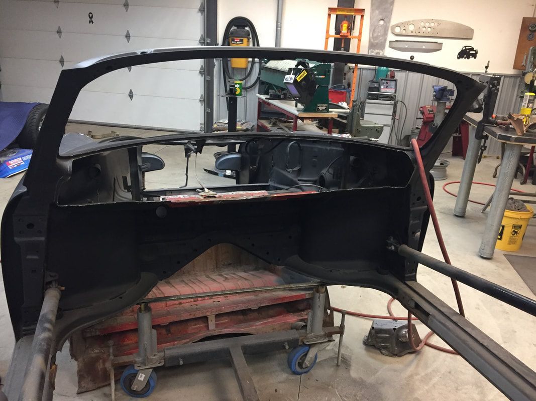 A black car is being built in a garage
