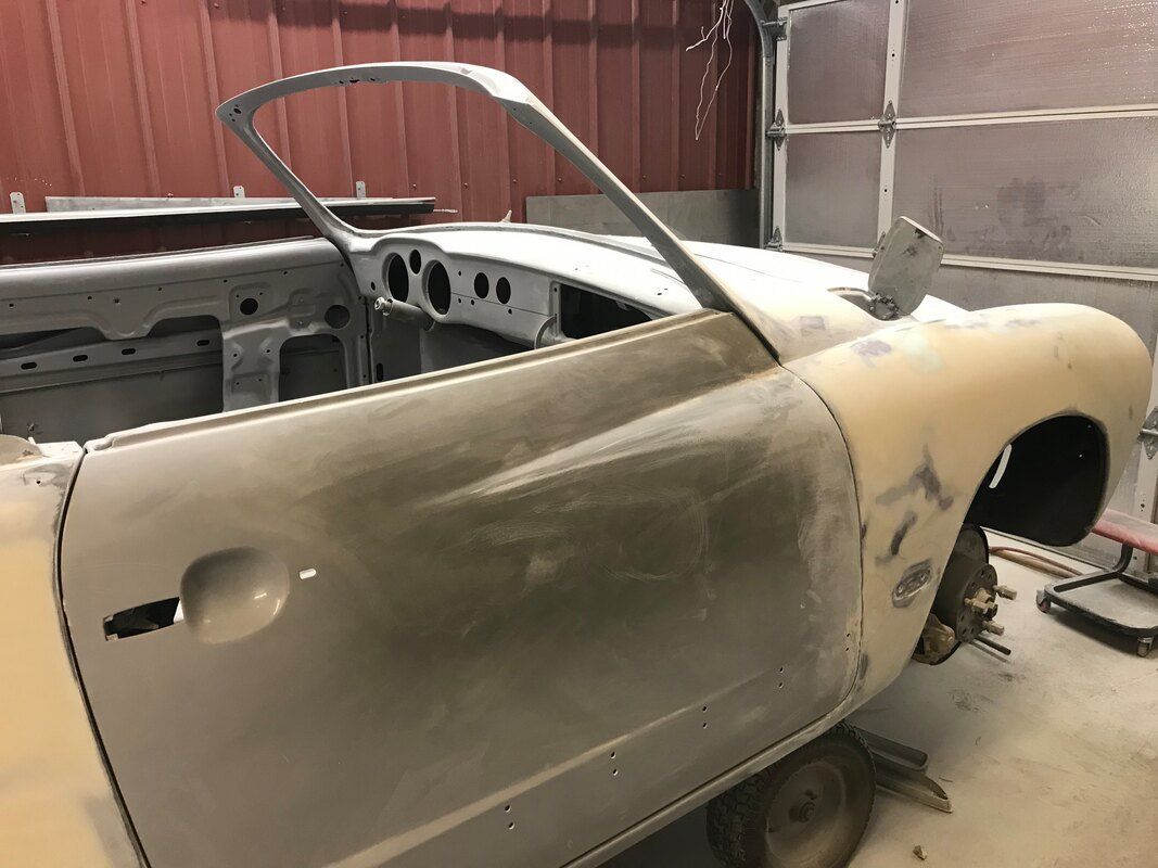 A car is sitting in a garage with its door open.