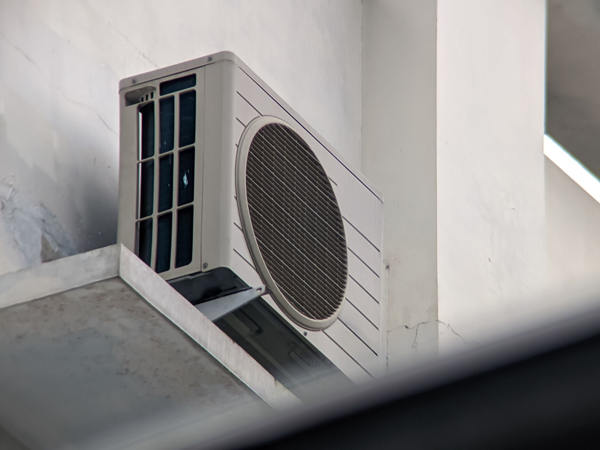 An exterior air conditioning unit mounted on a building wall.