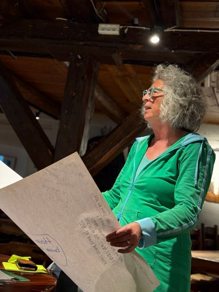 En kvinde i en grøn kjole holder et stykke papir i hænderne.