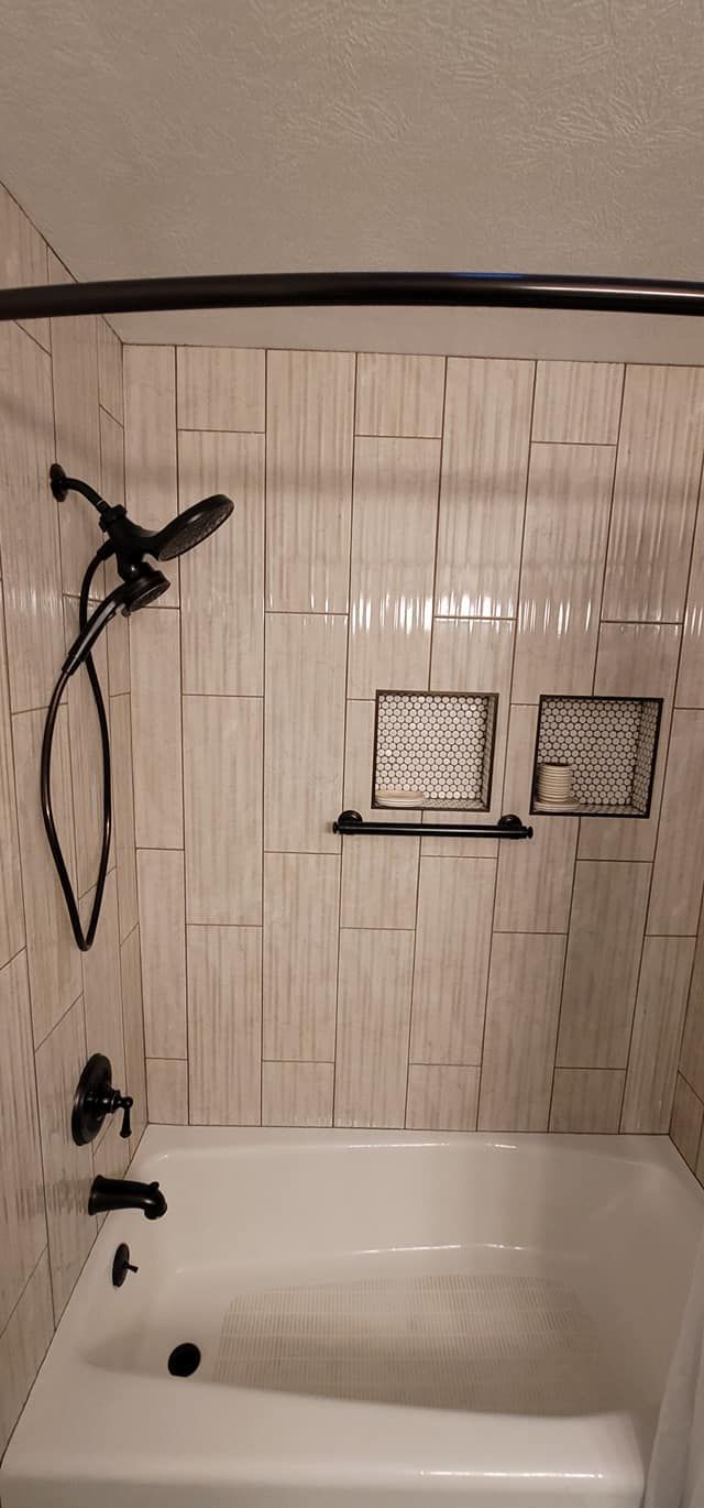 A bathroom with a bathtub and a shower head.