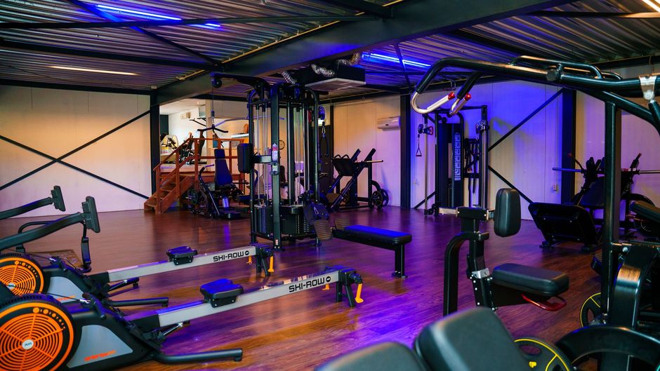 Een grote fitnessruimte vol met veel fitnessapparatuur.