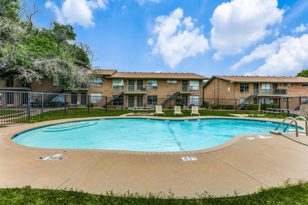 There is a large swimming pool in front of a building.