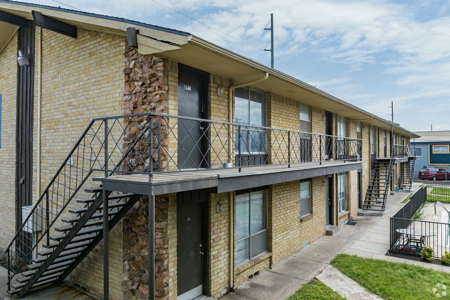 A brick apartment building with stairs leading up to the second floor