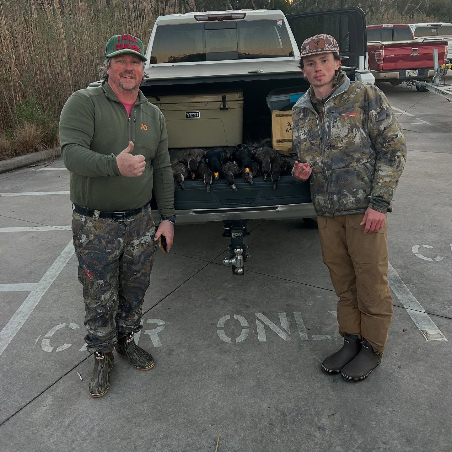 Two men standing in front of a truck that says car only