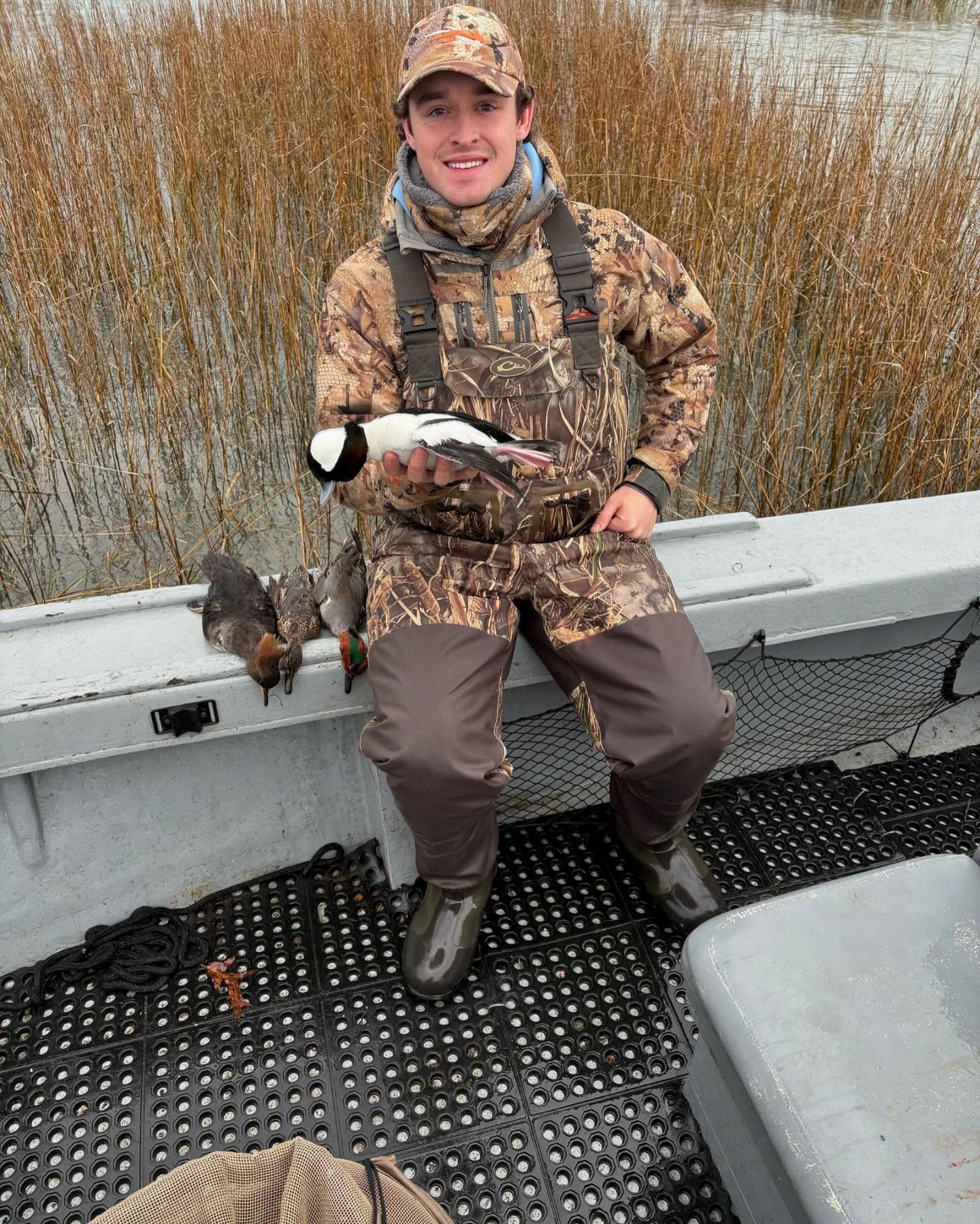 A man is sitting on a boat holding a duck.