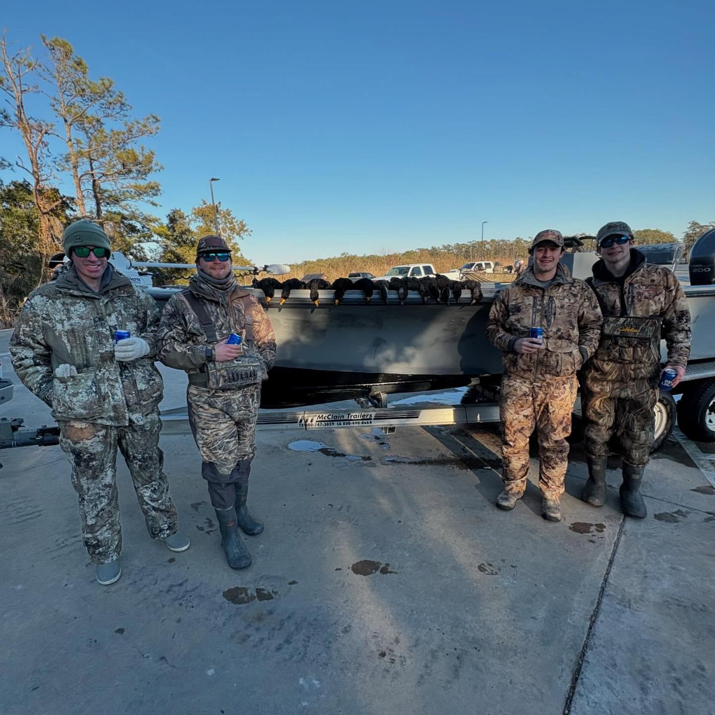A group of men in camouflage standing in front of a boat