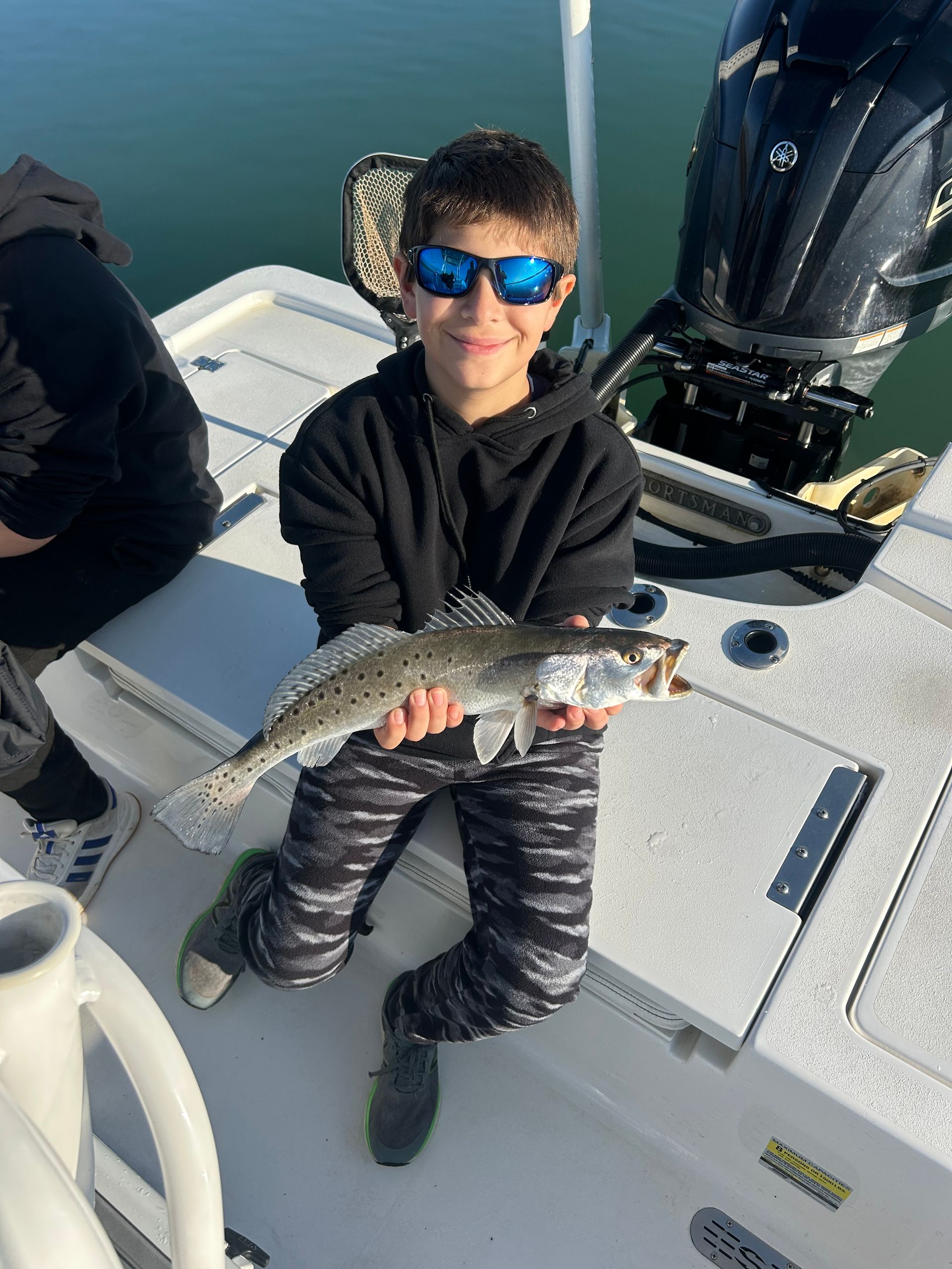 Two men are standing next to a boat with a bunch of ducks on it.