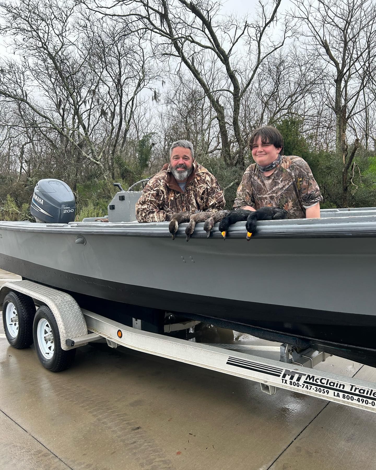 Two men are sitting in a boat on a trailer.