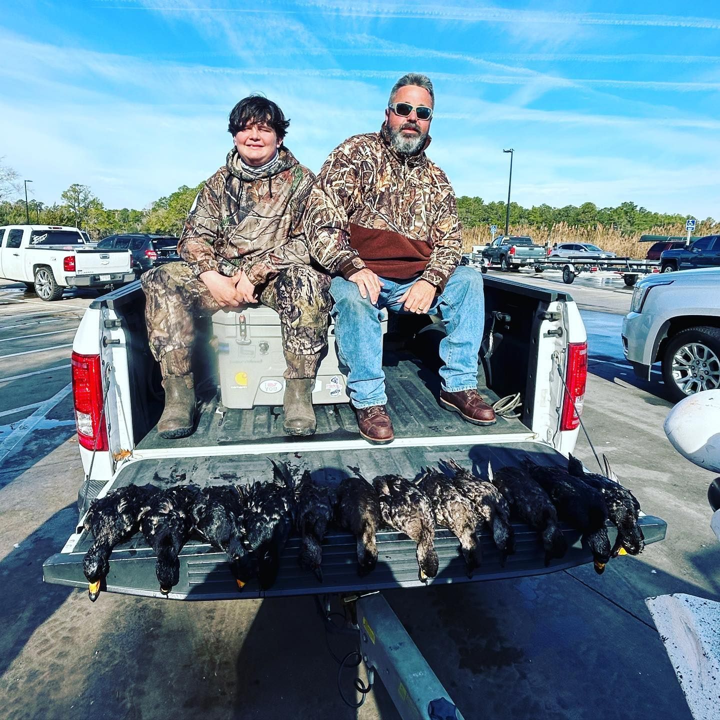 A man and a boy are sitting in the back of a truck.